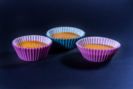 A closeup shot of uncooked homemade carrot cupcakes isolated on a blue surface