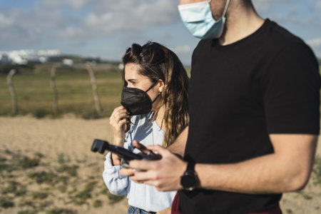 A shot of a Caucasian couple from Spain controlling the drone with remote control