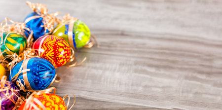 A colorful Easter banner with Easter Eggs on a wooden background with copy space