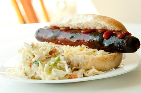 A closeup shot of a delicious hot dog served with saladの写真素材