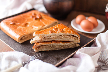 A closeup of appetizing typical Russian stuffed sweet pie arranged with a white cloth