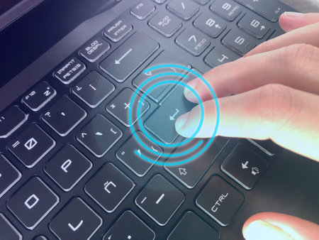 A closeup shot of a hand pressing the enter button on a keyboard with blue hud emphasizing it