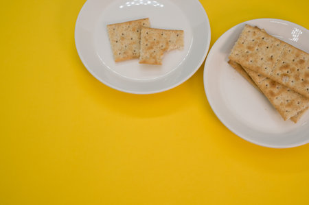 The two plates with salty crackers on a yellow surfaceの写真素材