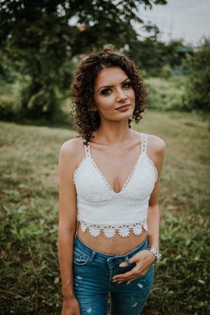 A vertical shot of a young sexy Bosnian girl posing in the gardenの写真素材