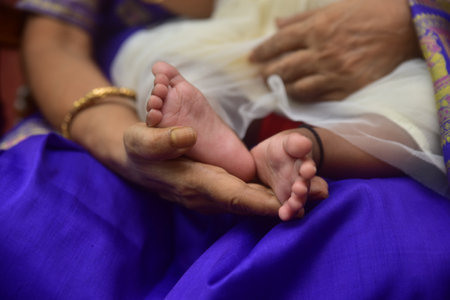 Baby feet in mother hands. Tiny Newborn Baby's feet on female Shaped hands closeup. Mom and her Child. Happy Family concept.の写真素材