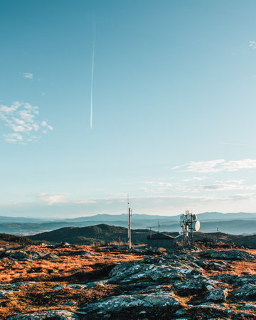 A vertical shot of a landscape with antennas and industrial infrastructuresの写真素材