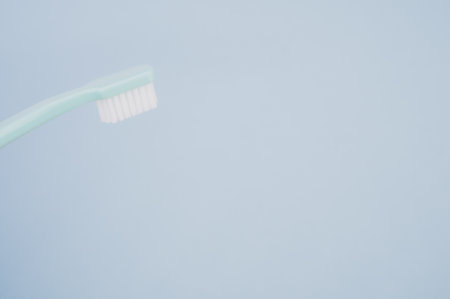 A blue toothbrush on pastel blue background with a copy space