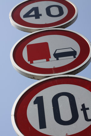 A vertical shot of three traffic signs on a blue backgroundの写真素材