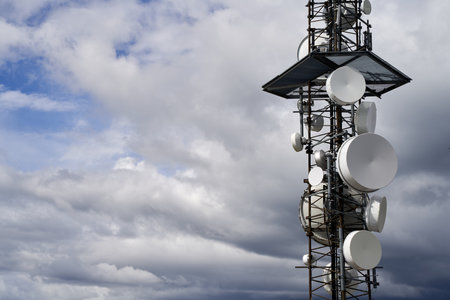 A telecommunications towers against cloudy sky backgroundの写真素材