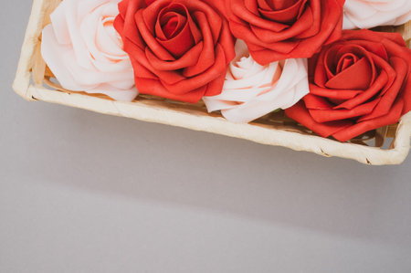 Beautiful red and white roses in a box isolated on a grey backgroundの写真素材