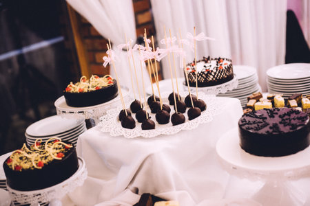 A closeup shot of delicious cakes with chocolate desserts on the catering tableの写真素材
