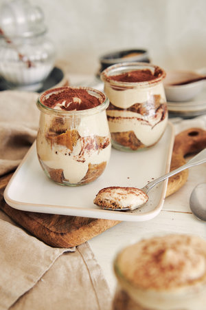A vertical shot of delicious tiramisus served in a cupの写真素材