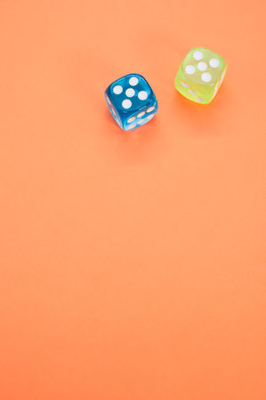 A vertical shot of colored dice cubes on a colorful background