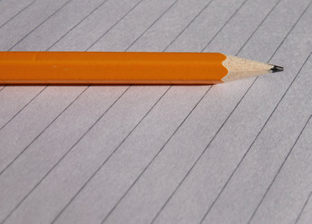 A closeup of a sharp pencil set on an open notebookの写真素材