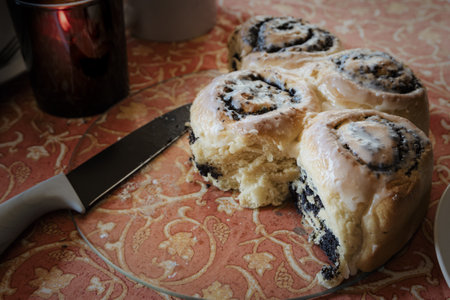 Birthday cake cinnamon roll (Zimtrolle) on a plate with a knifeの写真素材