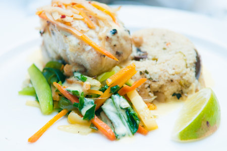 A closeup shot of chicken with a veggie salad on the side