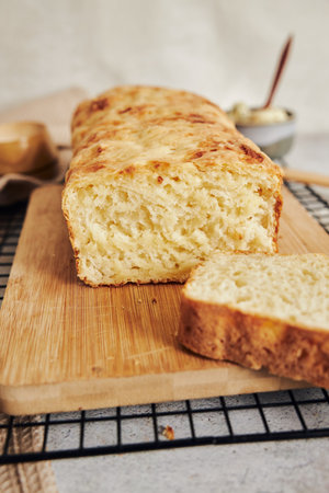 A closeup shot of delicious cheese bread with herb butter on a white table