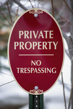 A red warning sign saying 'private property' and 'no trespassing'の写真素材