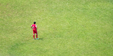 A lonely football player in a football fieldの写真素材