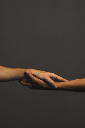 A vertical shot of a pair of hands gripping each other's wrists in a Roman-style forearm handshakeの写真素材