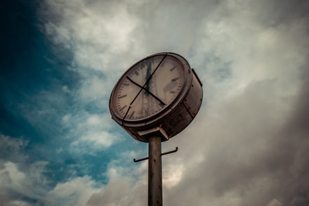 Derelict station clock against dramatic sky
