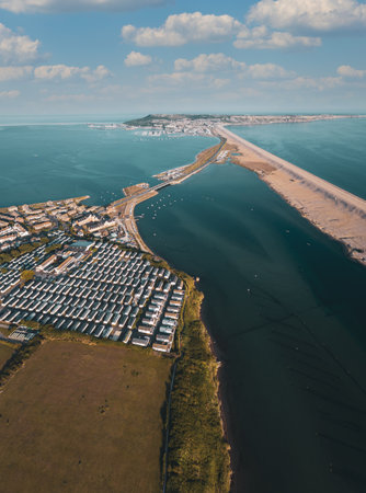 A vertical shot of houses in the Sandsfoot Beach with Portland in the distanceの写真素材