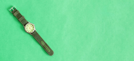 A top view of Men's accessories with green sports watches, on green pastel background. Isolated watch, banner.の写真素材