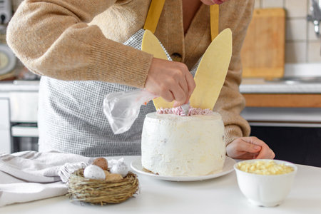Person baking and decorating cake shaped as a bunny.の写真素材