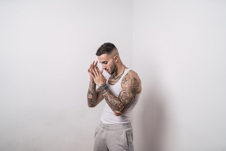 A portrait of a cool sexy tattooed Spanish male posing isolated on a white backgroundの写真素材