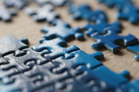A selective focus shot of blue puzzle pieces on cardboardの写真素材