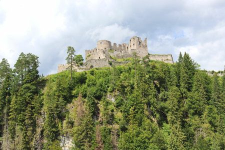 A low angle hsot of historic Ehrenberg Castle in Reutte, Tyrol, Austria under a cloudy skyの写真素材
