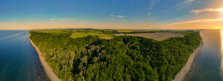An aerial shot of an island of green landscape with blue sea waters and clear skyの写真素材