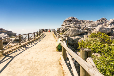 A beautiful road with a wooden fence leads to the sea against blue sky background,Torcal Antequeraの写真素材
