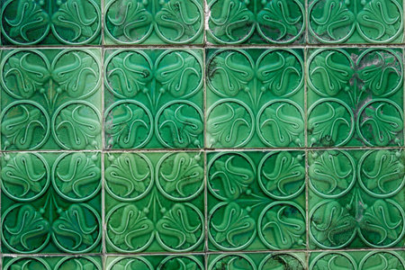 A background of green tiled flooring with decorative flowers engraved on the stonesの写真素材