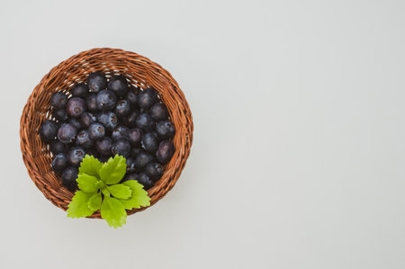 A top view of blueberries and a leaf in a basket on a white backgroundの写真素材