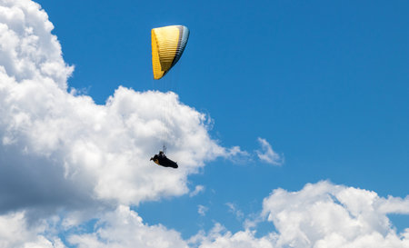 A person parasailing in the cloudy sky