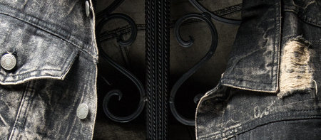 A closeup shot of a weathered denim jacket on a fence