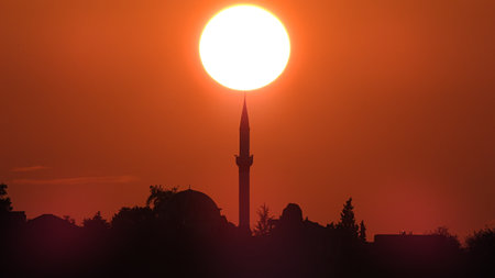 The silhouette of a mosque during a scenic sunsetの写真素材