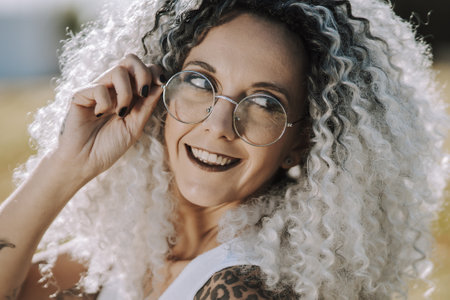 A curly-haired Spanish cute woman in a field of daisies