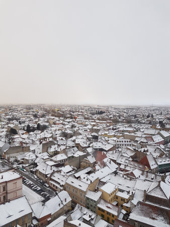 A beautiful high angle view of the roofs of the houses covered in snow on a cold winter dayの写真素材