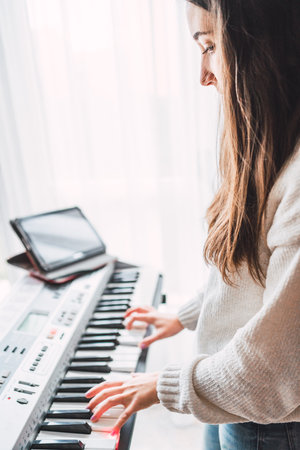 A Spanish girl playing on an electronic musical instrument synthesizer