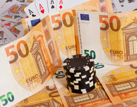 A closeup shot of 50 euro banknotes with poker chips and playing cardsの写真素材