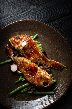 A closeup shot of fried fish with grilled greens on a plate