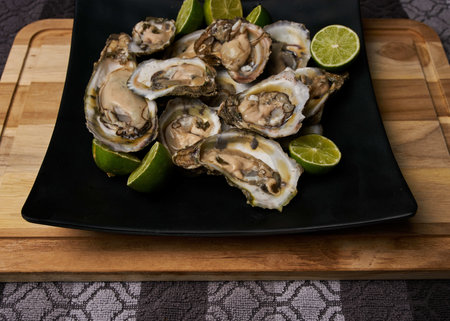 A closeup shot of fresh oysters with lime slicesの写真素材