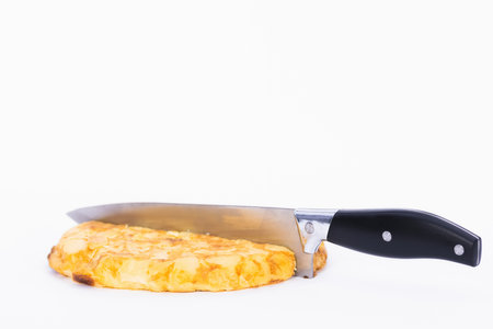 A knife cutting an omelet isolated on white backgroundの写真素材