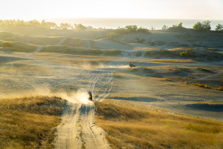 A wonderful view of people with pickup trucks driving on dusty roads of a steppeの写真素材