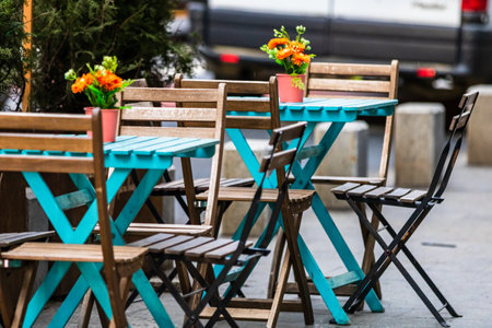 A closeup of empty tables with empty chairs at a local outdoor restaurant in Bucharest, Romania,...