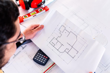A closeup shot of an architect-engineer analyzing a blueprint
