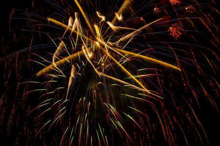 Bright festive fireworks. Light rays on a dark sky background. Fireworks