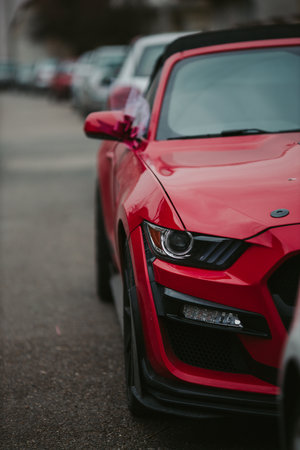 A selective focus shot of a red racecar parked in a line of carsの写真素材